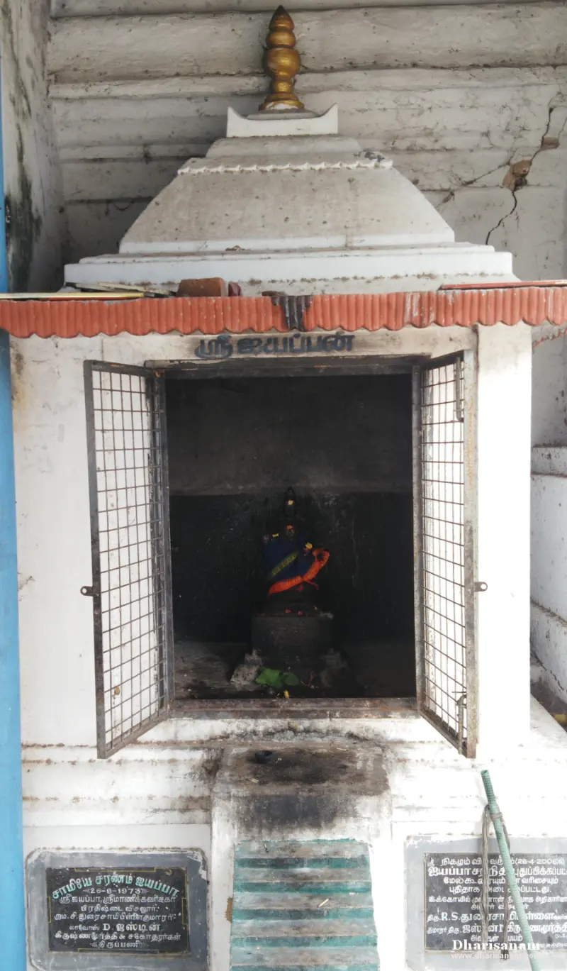 Small white shrine with a domed top, an open iron grill door and two stone plaques at the foot of its steps