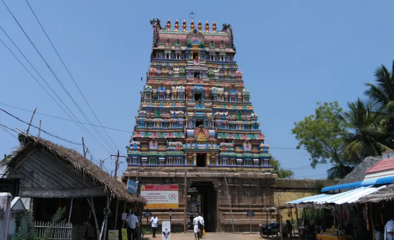 Front view of the multi-tiered, brightly painted Rajagopuram above the entrance gateway, with shops either side