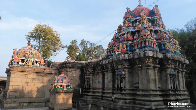 The stone sanctum building carries a colourful tower with a red dome; smaller painted domes show on its left