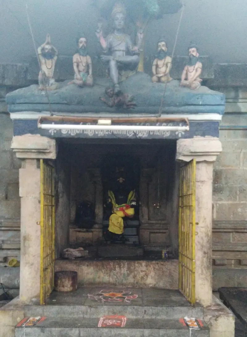 Stucco figures of a seated deity and four sages above a shrine doorway