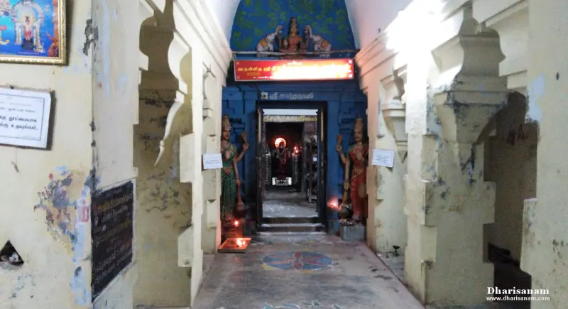 A narrow passage leading to a lit sanctum, with a standing figure on either side.