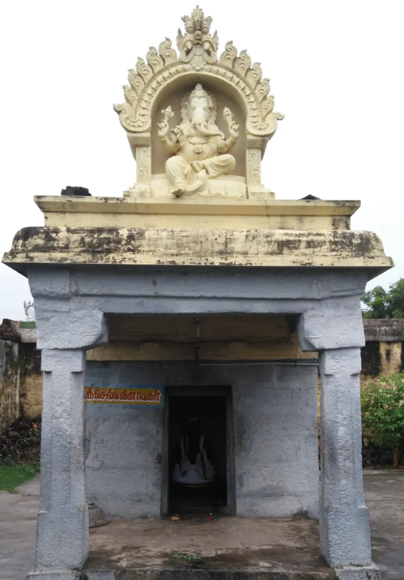 A small shrine on pillars with a cream-coloured relief of Vinayakar above it and a Tamil name board at the door.
