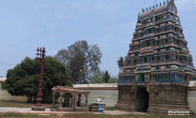 Tall sculpted tower beside a red flagstaff and pillared shelter
