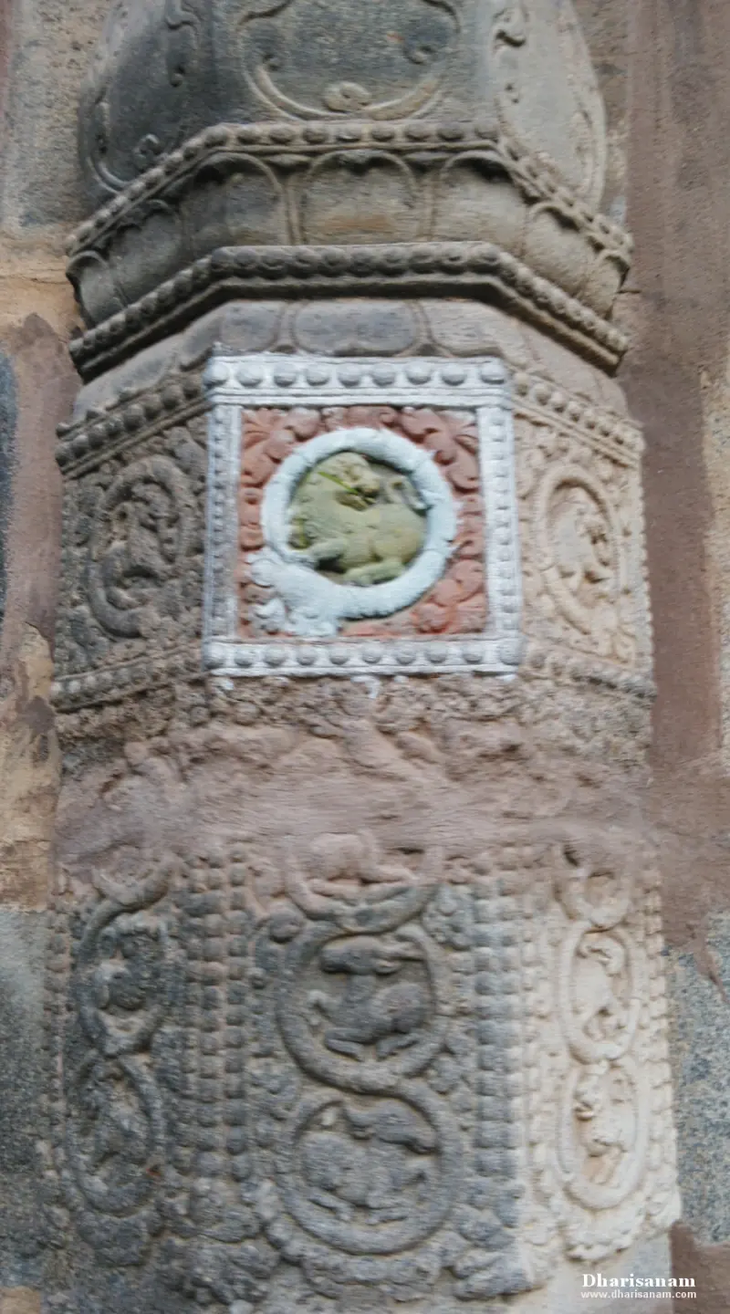 Carved stone pillar with a small painted animal relief in a white circle and square frame