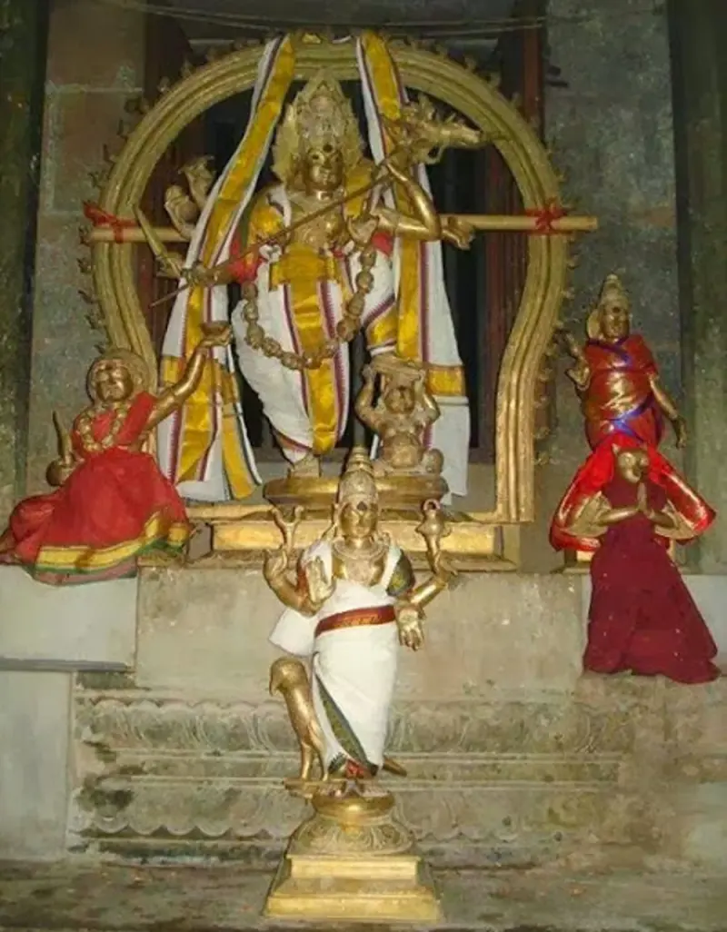 A group of bronze idols dressed in cloth: a tall central figure, a standing figure in front and two figures at the sides