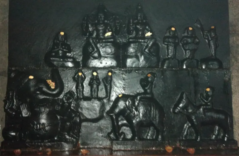 Panels of black stone relief showing an elephant-headed figure, riders on an elephant and a horse, and small figures
