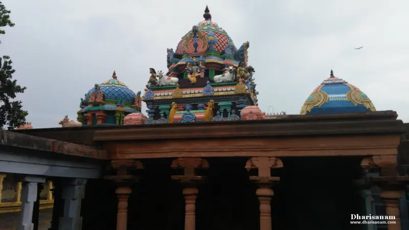 Painted domes and a tower with figures, seen above a pillared hall