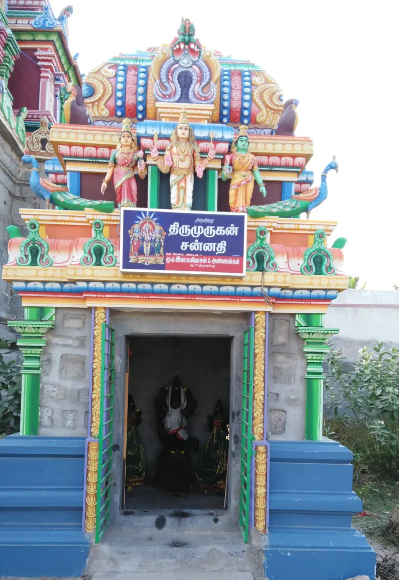 Colourful Murugan shrine with peacock sculptures and a Tamil board