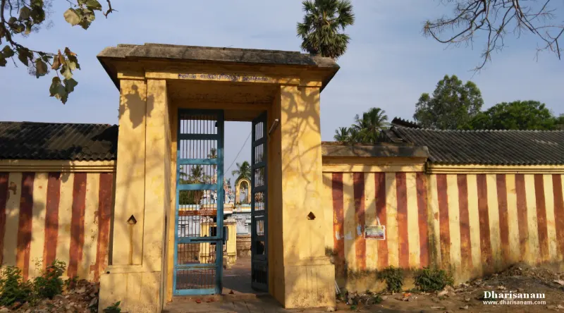 A yellow gateway with an open blue iron gate in a wall painted with red and cream stripes