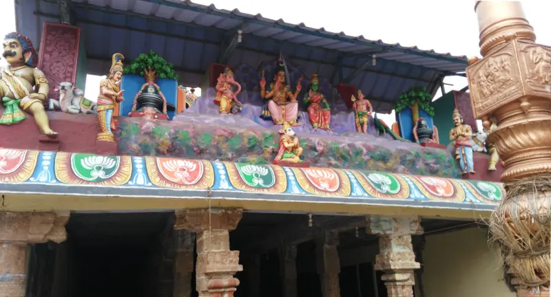 Row of colourful gods and a lingam above a pillared porch