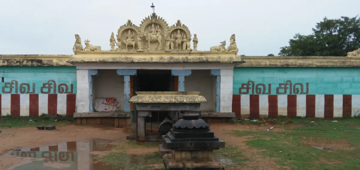 A low porch topped with painted figures, a Nandi pavilion in front, and walls reading Siva Siva in red and white.