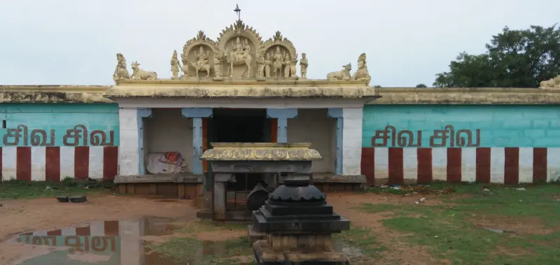 A low porch topped with painted figures, a Nandi pavilion in front, and walls reading Siva Siva in red and white.