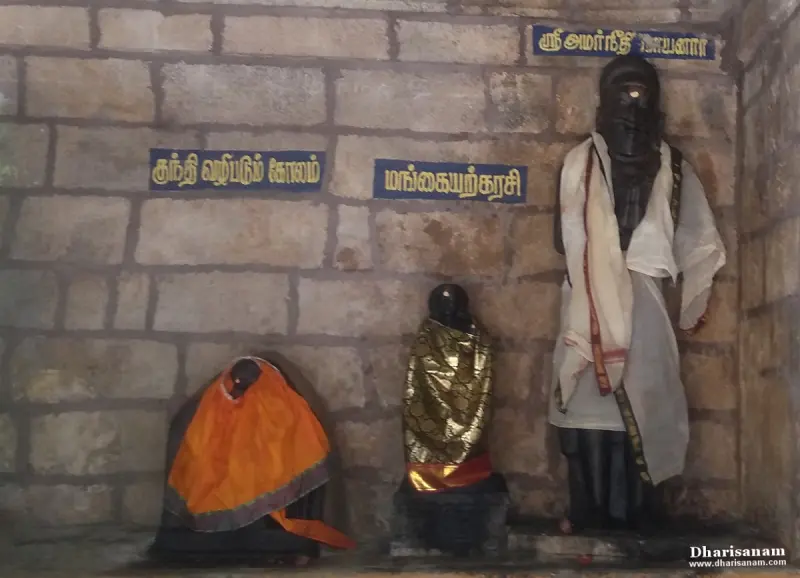 Three idols against a stone wall with Tamil name boards, one of them naming Amaraneethi Nayanar