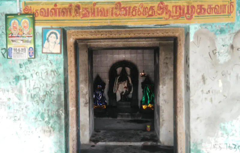 A small shrine with a Tamil name board above, and idols of Murugan with two consorts seen inside