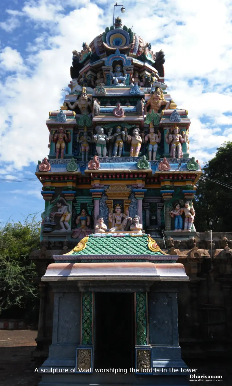 A colourful shrine tower with painted figures on several levels, a small porch at its base