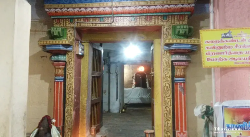 Brightly painted doorway with a lit lamp inside and a yellow notice board on the right