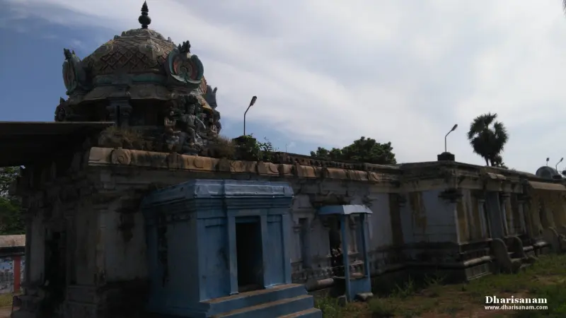 Old stone wall and corridor with a blue shrine in front and the sanctum roof rising behind