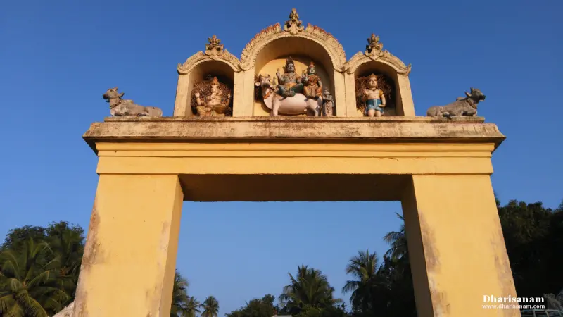 A yellow arch seen from below, with figures in niches and a bull at each end, against a blue sky