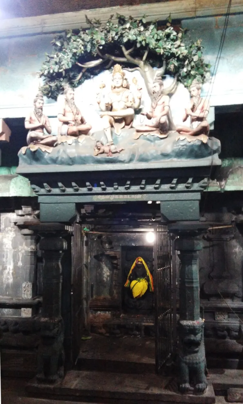 Shiva teaching four sages sculpted over a dark door