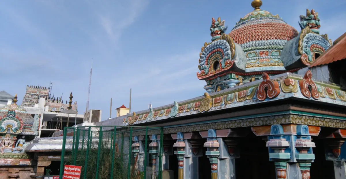 Painted gopuram top above a pillared hall