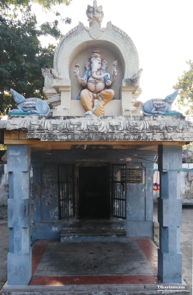A small open-pillared shrine with a painted Vinayakar figure in an arch above the door and a mouse on either side
