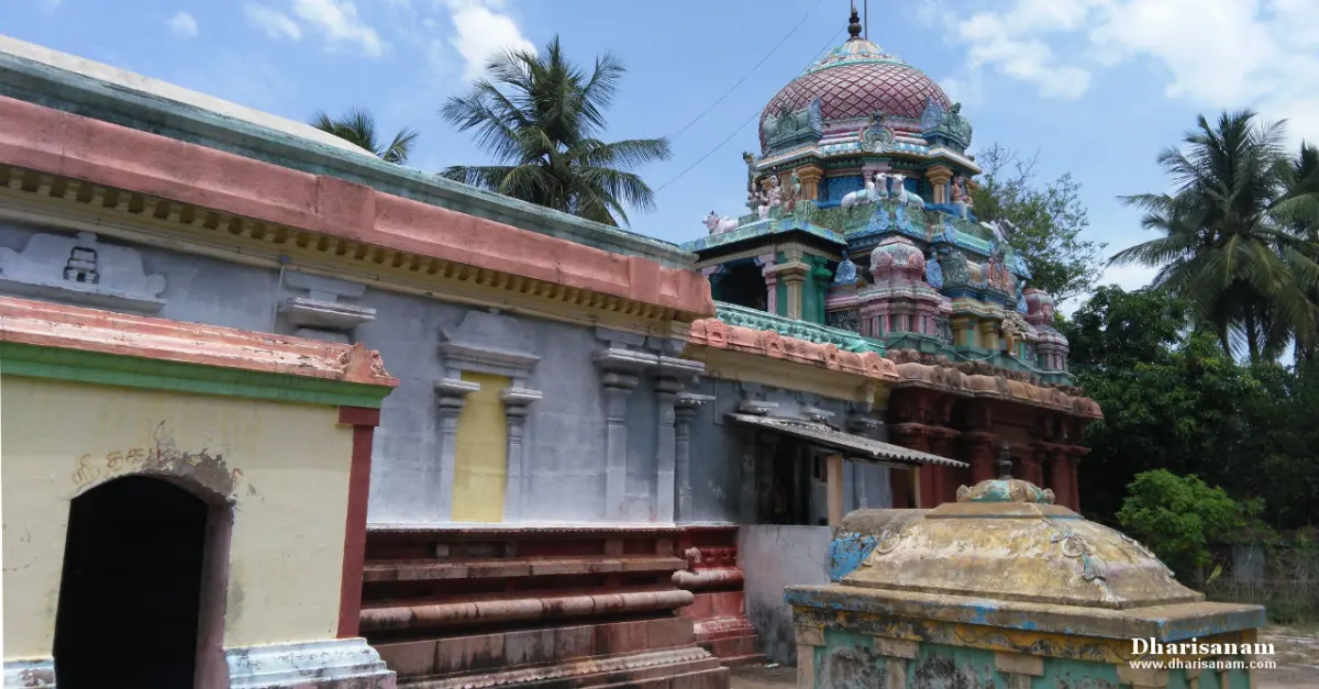 The temple's colourful domed tower rising behind a painted outer wall, with palm trees around