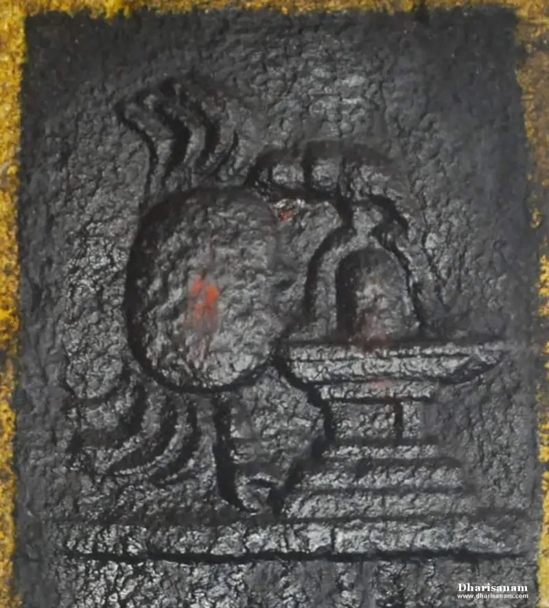 Rough black panel with a rounded form beside a lingam on a stepped base