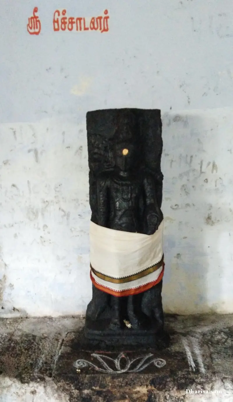 Black stone idol in a white cloth, with its name painted in red Tamil letters above
