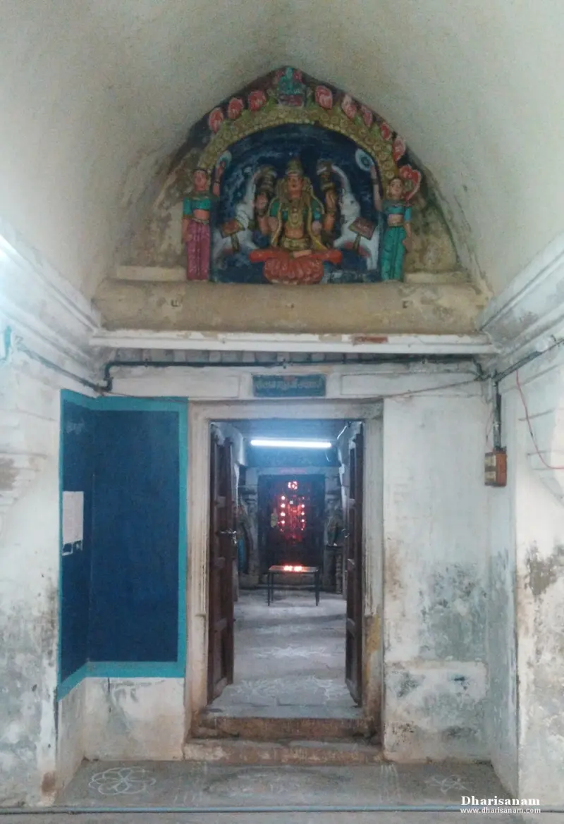 A doorway into an inner shrine, topped by a coloured sculpture of a seated goddess with attendants