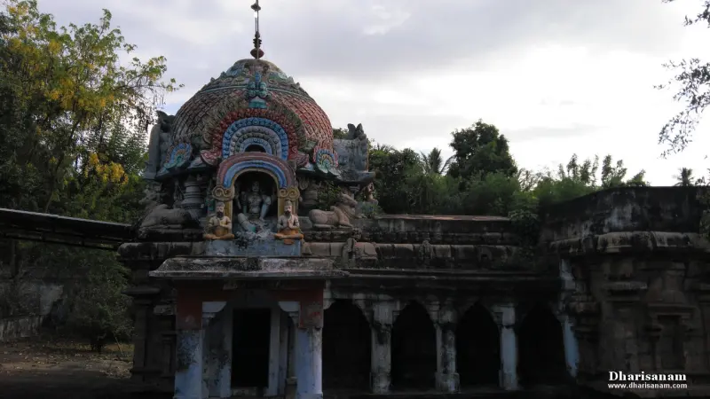 A domed tower with painted figures above a small shrine, beside a pillared stone corridor