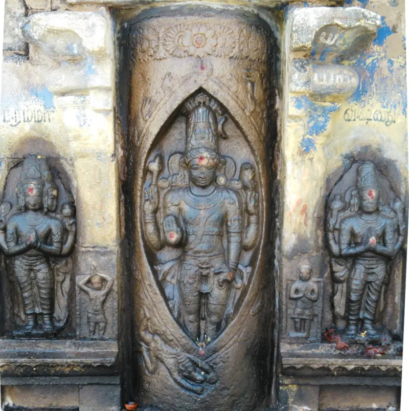 A stone relief of a tall four-armed figure in an oval niche, with smaller figures kneeling on both sides.