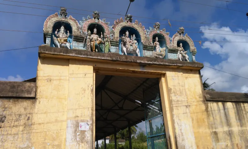 Yellow gateway with painted stucco figures in arched niches above it