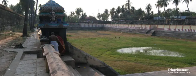 A wide stepped tank with grass and a little water, a small domed shrine at the left corner