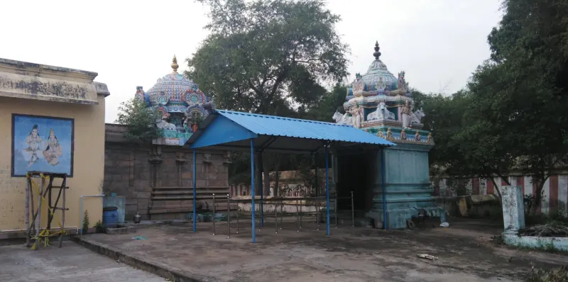 Two small painted shrine towers with a blue-roofed shelter between them.