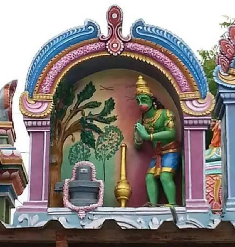 Green stucco Anjaneyar with folded hands before a Shivalingam