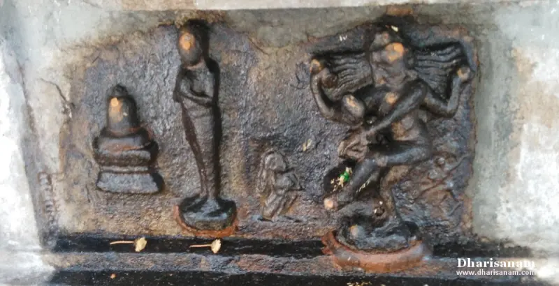 A dark stone panel with small standing figures and a dancing figure at the right