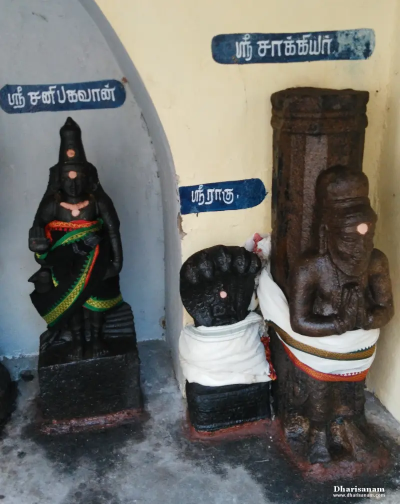 Three dark idols with Tamil name boards in a corner shrine