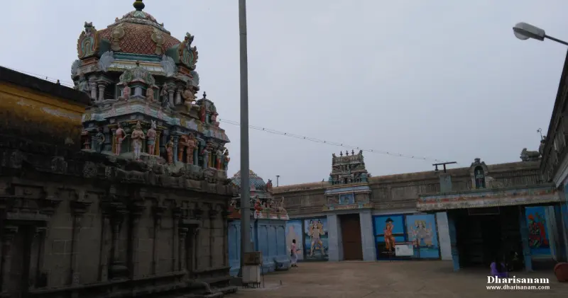 A shrine roof with painted figures at the left and a gateway beyond with painted wall panels