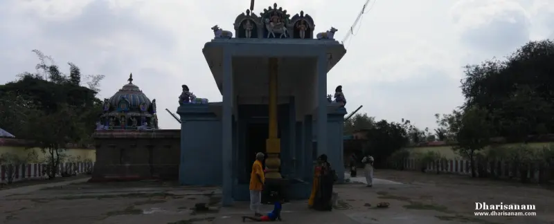 A pillared hall with a tall flagstaff and people around