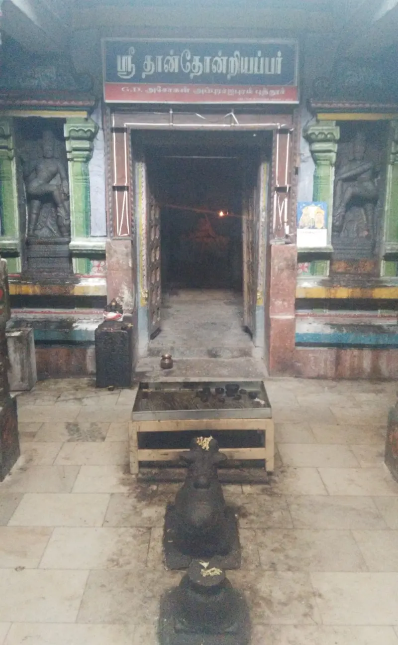 A doorway with guardian statues on both sides and a Nandi bull facing it