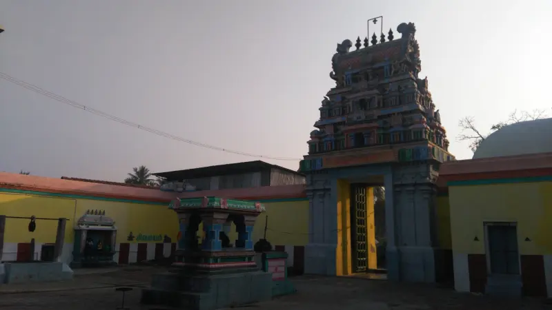 A paved courtyard with tower, small shrine and yellow walls