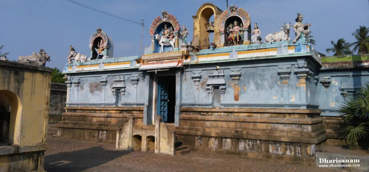 Blue-grey shrine wall with a doorway and many painted figures and bulls along its roof edge