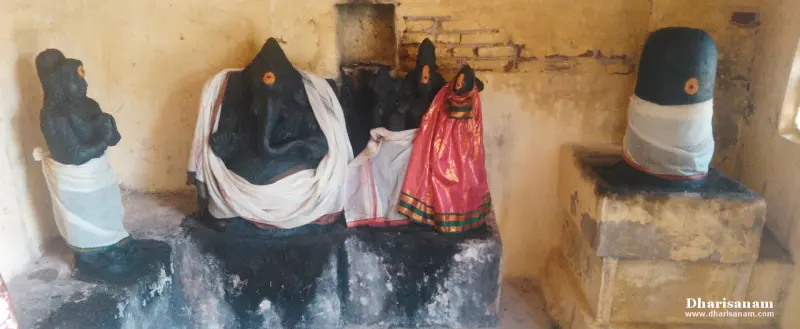A Vinayakar idol and other idols in cloth, with a lingam on a stone base at right.