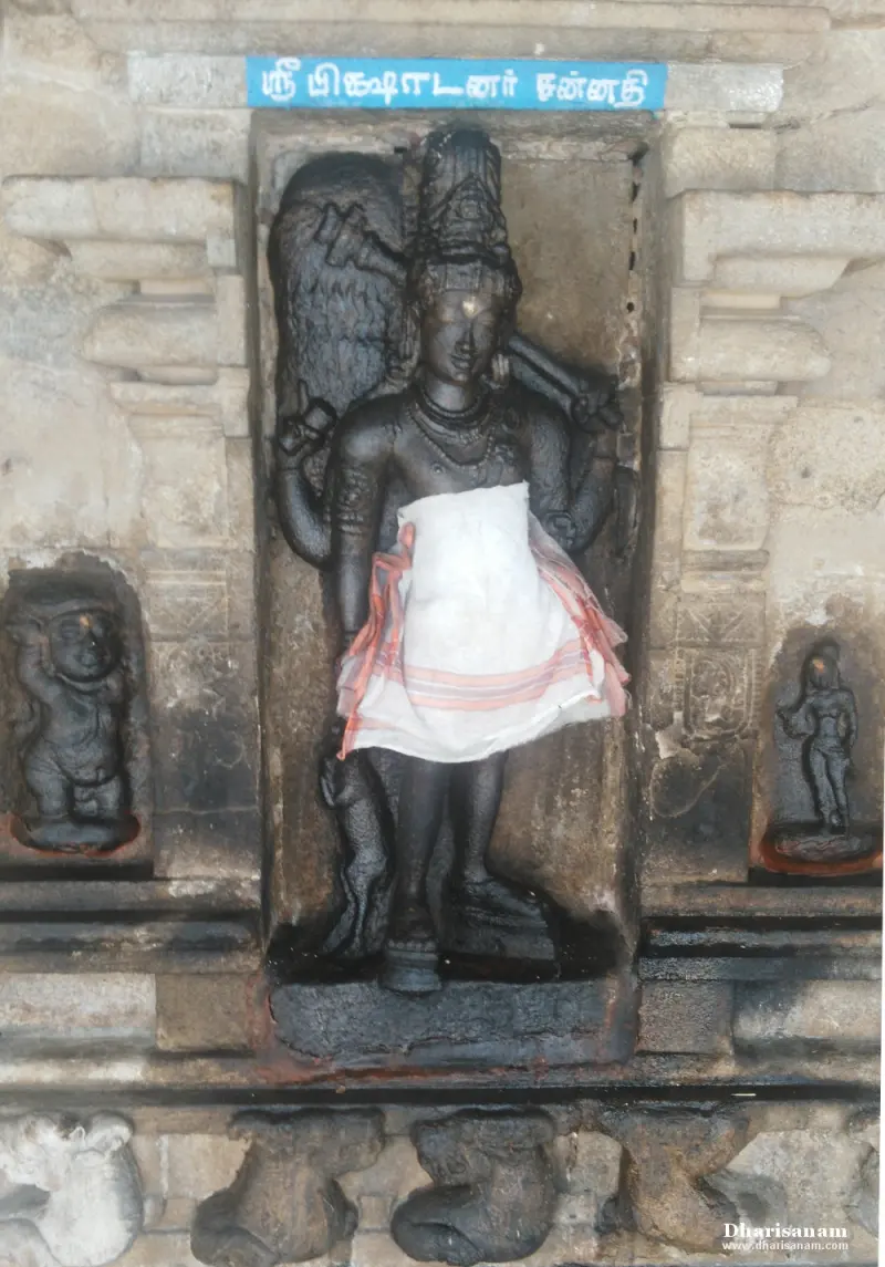 Standing black stone idol of Pitchandavar in a niche, with a Tamil name board above