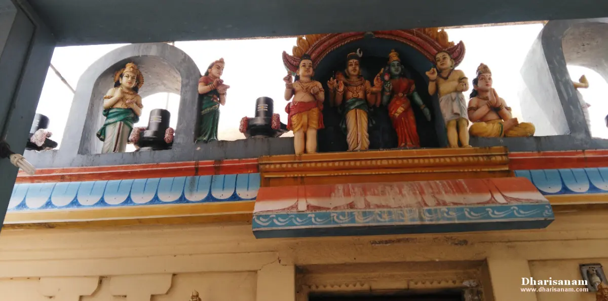 Colourful painted figures, including linga forms, on a ledge above a doorway