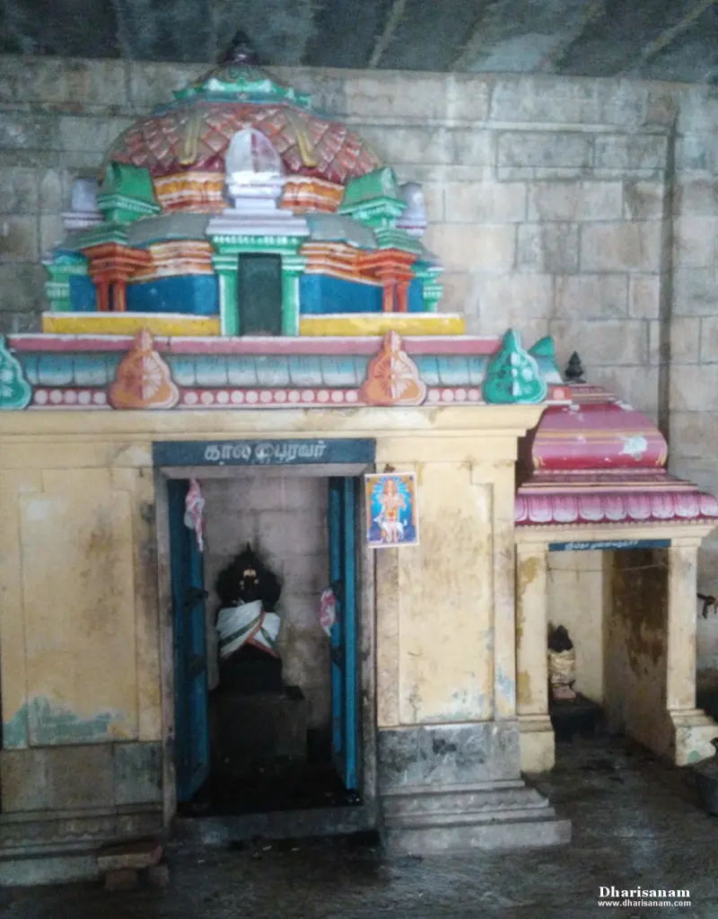 A small colourful shrine with a blue board reading Kala Bairavar and a dark idol in white cloth inside