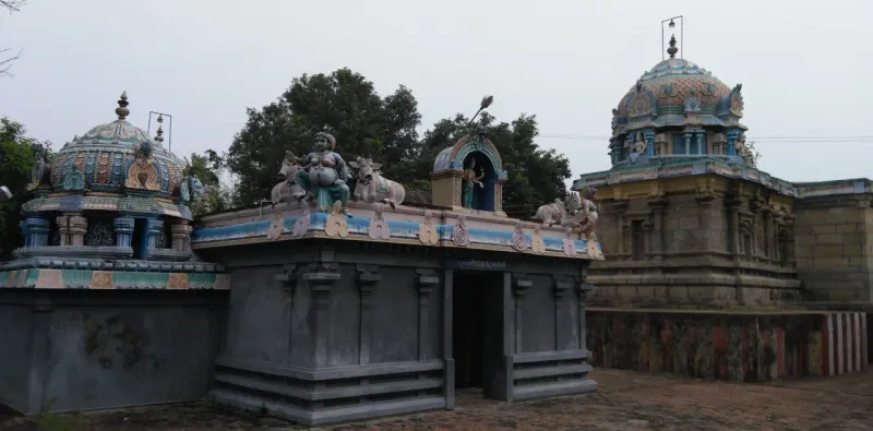 Two grey shrines with carved domes and parapet figures