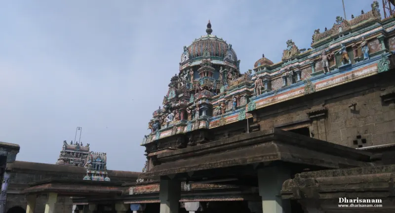 A domed tower with painted figures seen over the roof of a pillared hall