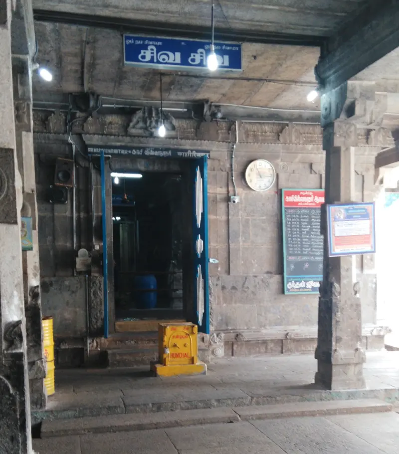 Carved entrance with blue board, clock and yellow box