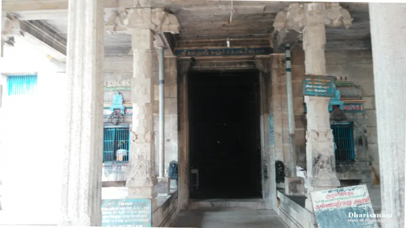 Stone pillars framing a dark doorway with grilled windows on either side
